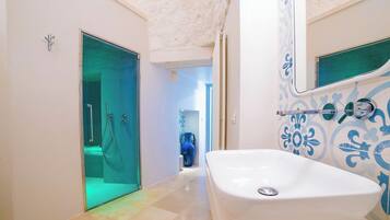 Un baño moderno con una bañera grande, una cabina de ducha de vidrio y azulejos decorativos.