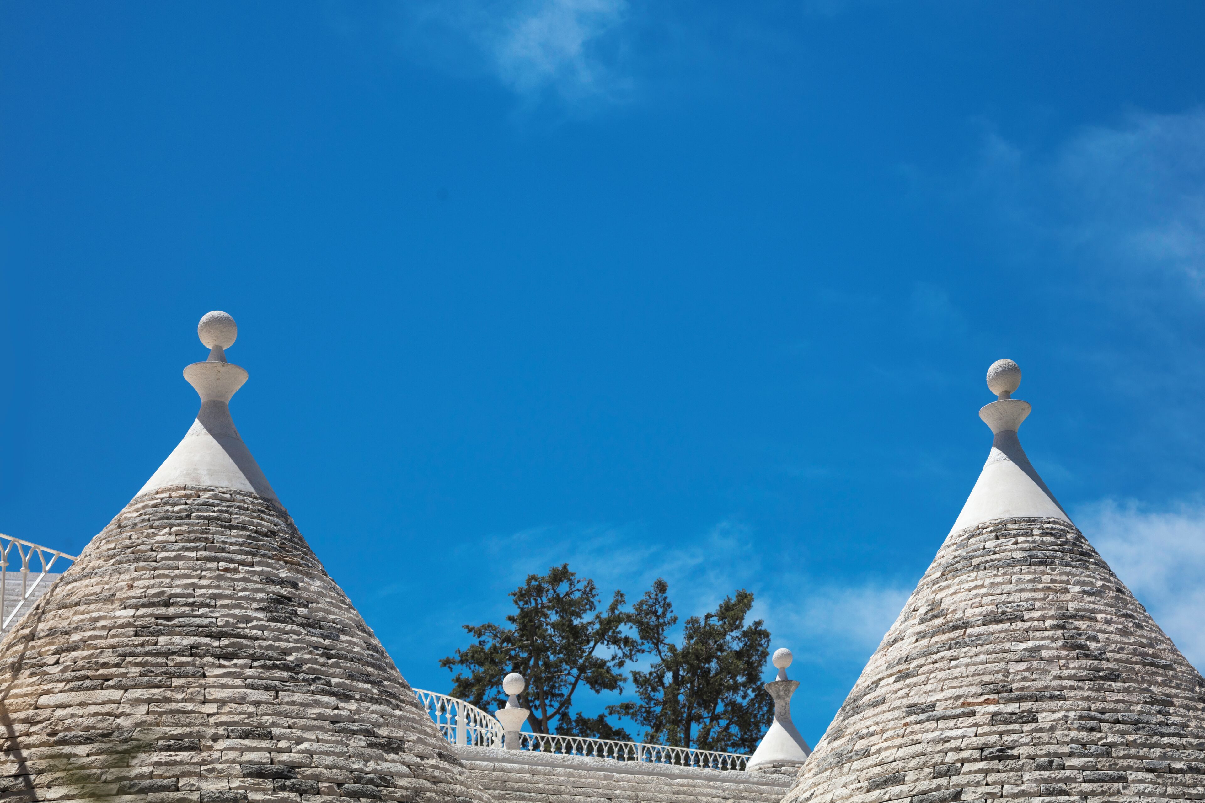 A stone structure with conical roofs and a white railing.