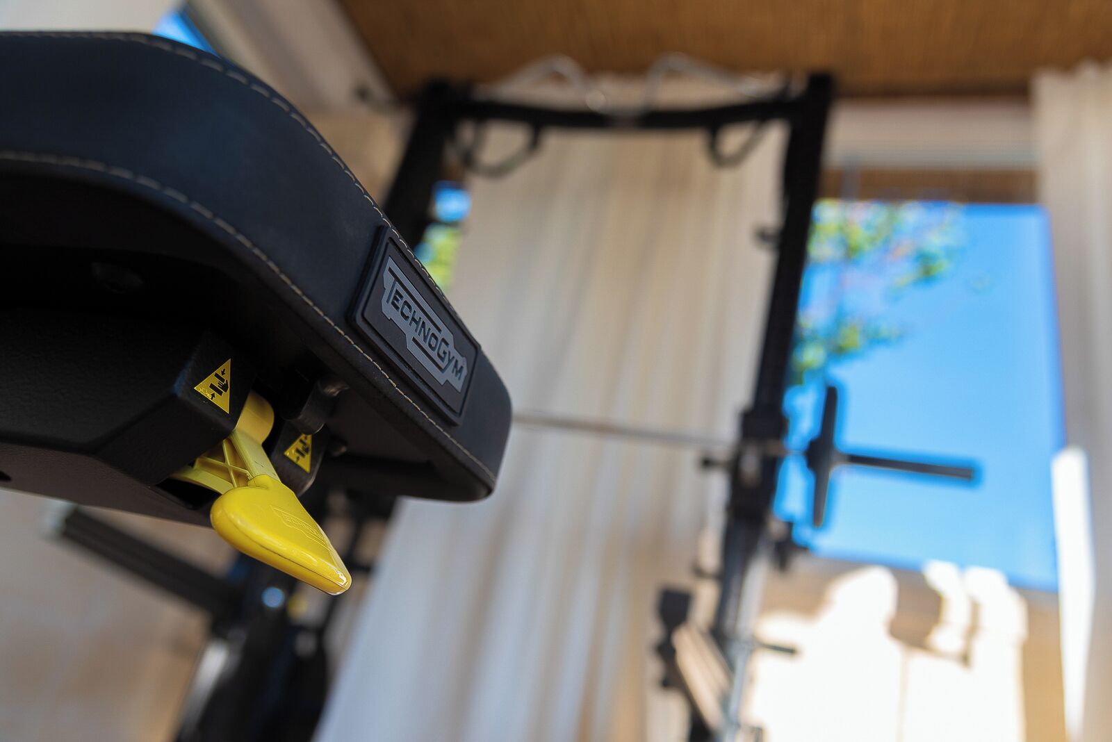 Une vue rapprochée d’un vélo avec un guidon jaune et un cadre noir, sur lequel on peut lire l’inscription « ECHNOGYM ».