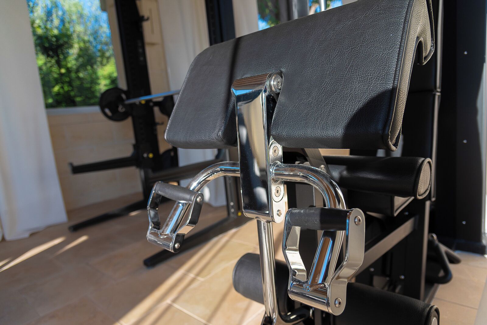 Een sportschool met trainingsapparatuur, waaronder een hometrainer en een halterbank.
