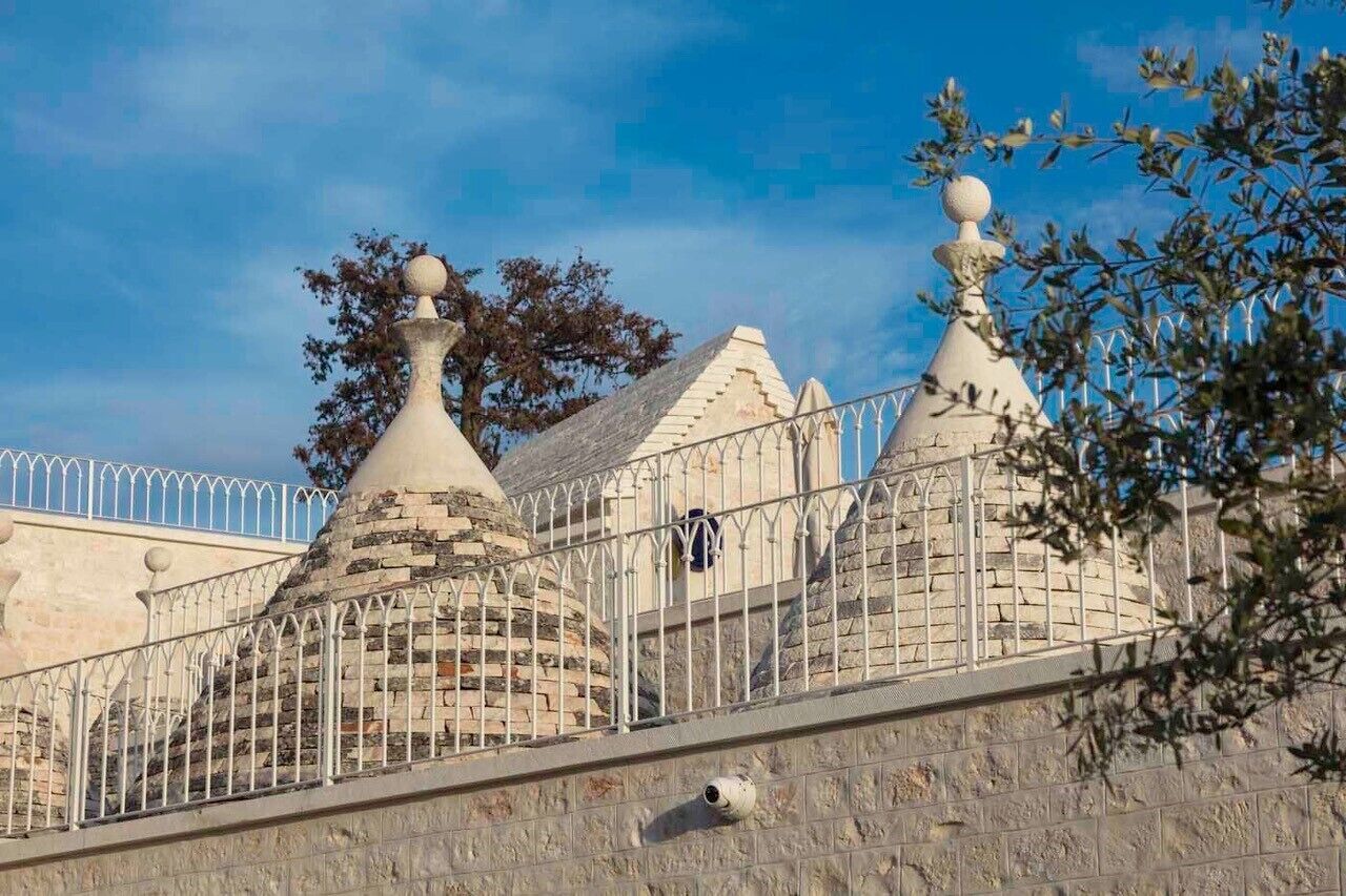 Un edificio de piedra con techos puntiagudos y una valla metálica.