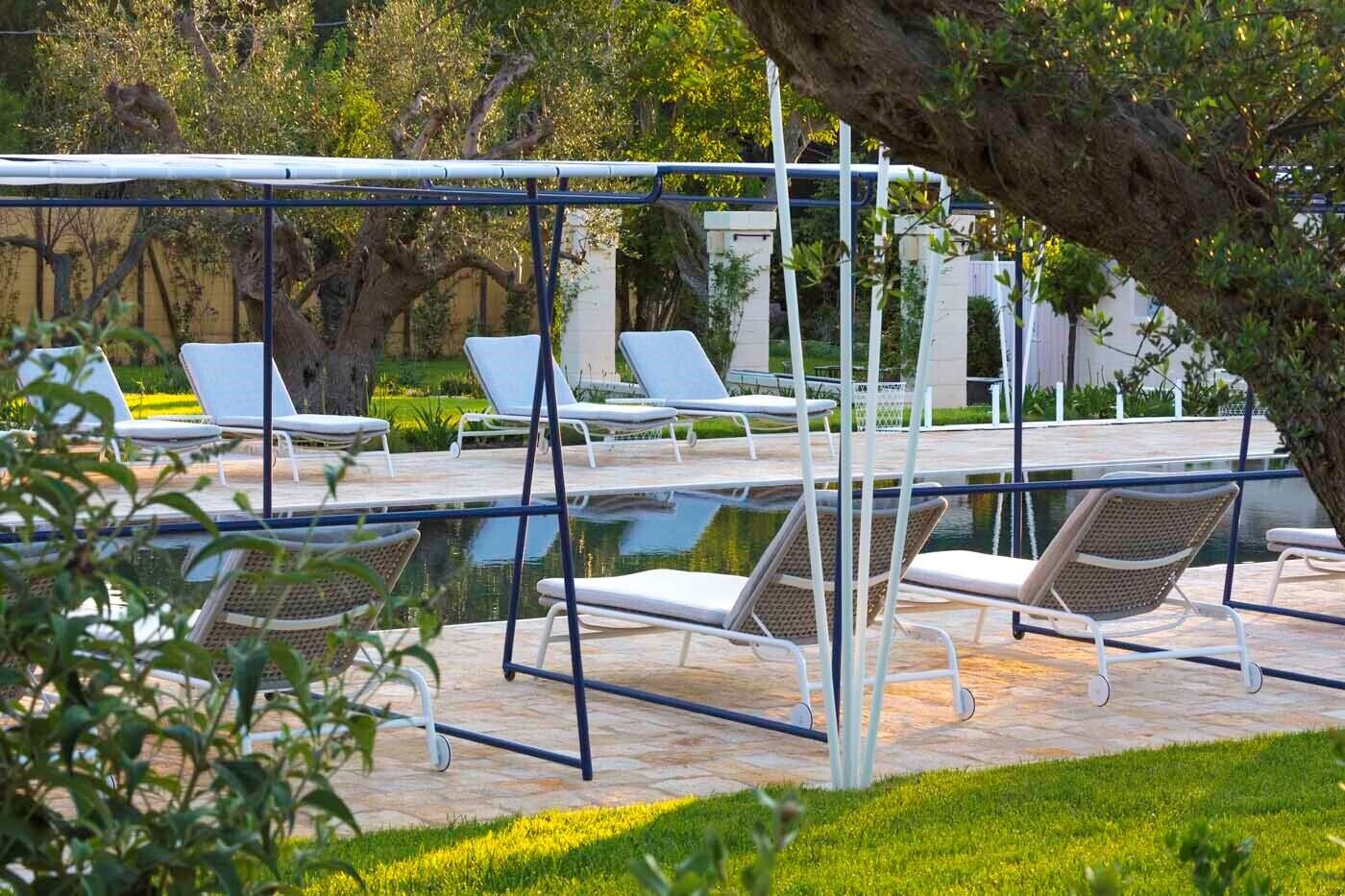 A pool area with lounge chairs and a swing set.