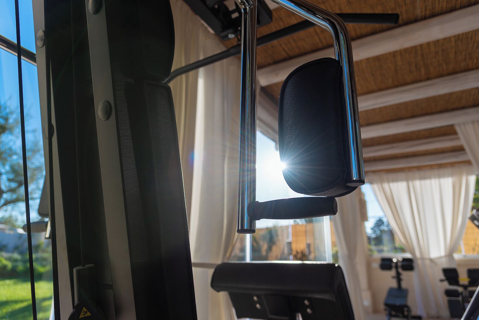 A gym with exercise equipment, large windows, and a view of the outdoors.