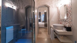 Un baño moderno con cabina de ducha de vidrio, un lavabo espacioso y un espejo.