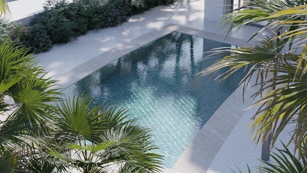 Un espace piscine moderne avec une eau cristalline, entouré d’une végétation luxuriante et bordé d’une terrasse blanche.