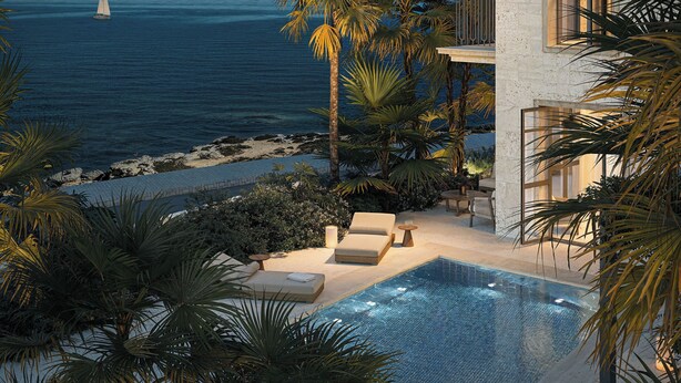 A pool area with a view of the ocean, palm trees, and a building with large windows. - Lantana Villas and Hotel (Pegeia)