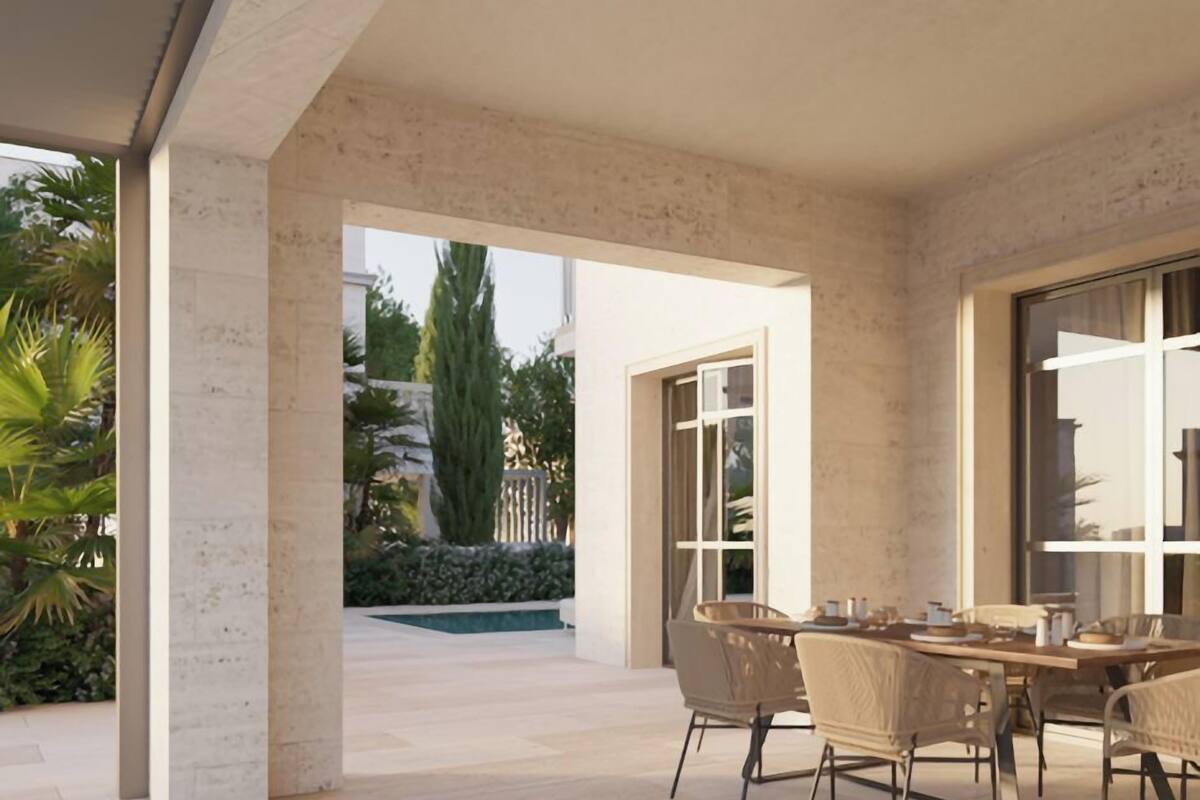 Un vaste patio comprenant une table et des chaises pour les repas, une vue sur le jardin extérieur et une grande fenêtre laissant entrer la lumière naturelle.