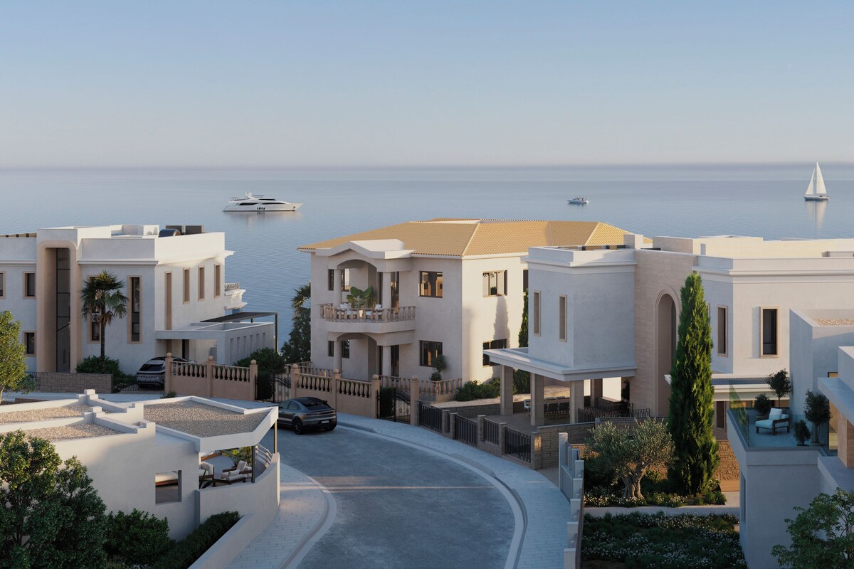 Un quartier résidentiel en bord de mer, caractérisé par une architecture moderne, une allée sinueuse et une vue sur la mer.