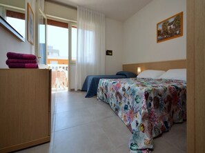 Een hotelkamer met een bed, een bureau en uitzicht op buiten.