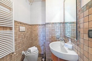 A bathroom with a white sink, a mirror, and a toilet. - Appartamento I 2 Pini (Sauze d'Oulx)