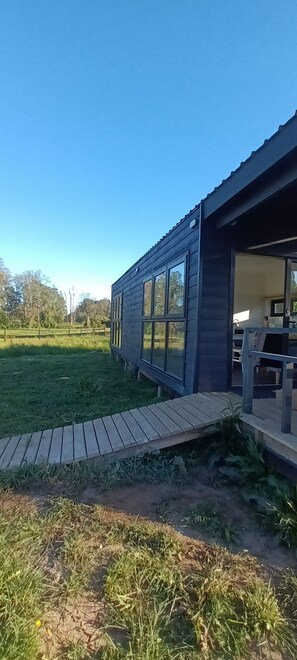 A modern house with a wooden deck and large windows. - Casa Chucao, countryside, nature, tranquility, nearby walks (Frutillar)