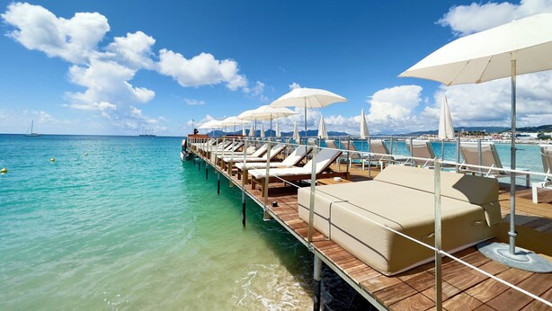 A deck with lounge chairs and umbrellas overlooking turquoise waters. - 2 bedroom apartment - Rue Macé - 1mn Plage Croisette & Palais (Cannes)