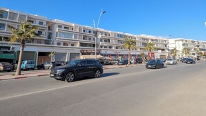 Et hotel med flere etager, balkoner, en restaurant og flere butikker i stueetagen.