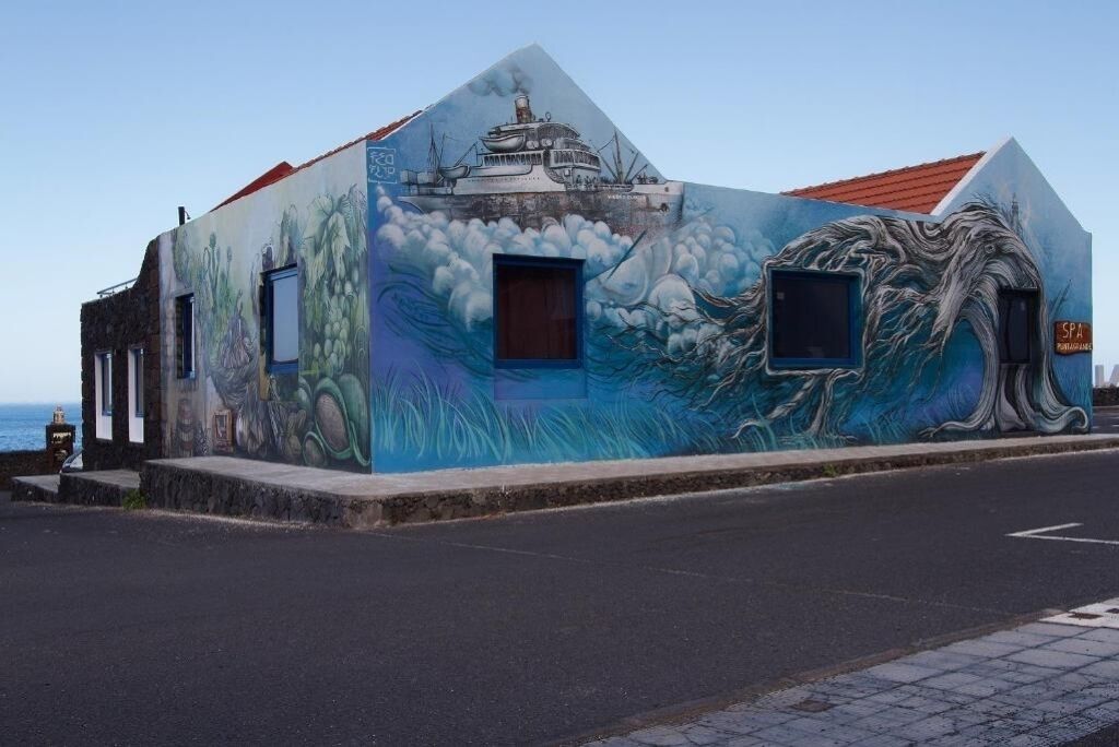 A building with a mural of a ship and waves on its facade.