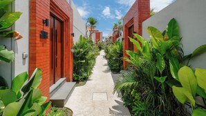 A narrow pathway flanked by red brick buildings with a clear sky above. - Three Brothers Villas and Suite Munggu (Munggu)