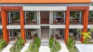 A modern two-story building with a flat roof, large glass windows, and a central staircase. - Three Brothers Villas and Suite Munggu (Munggu)