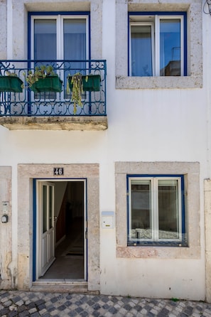 A building with a balcony, a door with a number, and a window. - Stylish Oasis in Trendy Historic Centre Quarter (Lisbon)