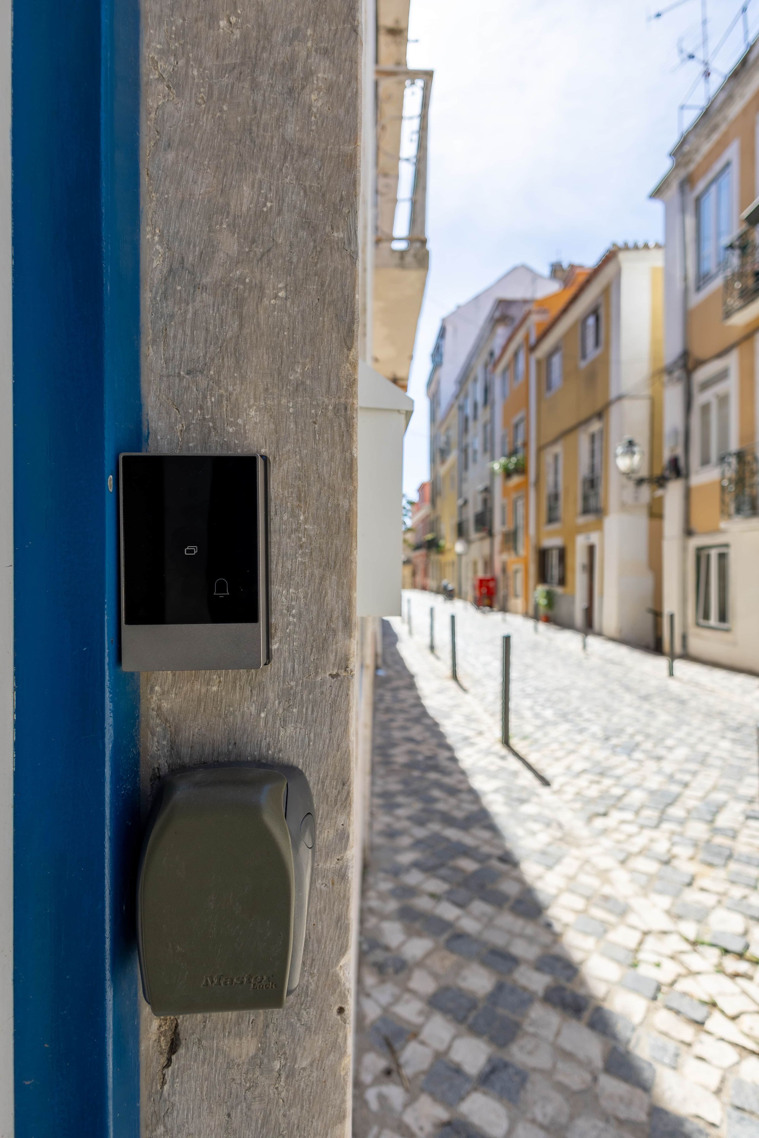Une vue de rue avec une porte bleue, un appareil électronique noir et un pavé.