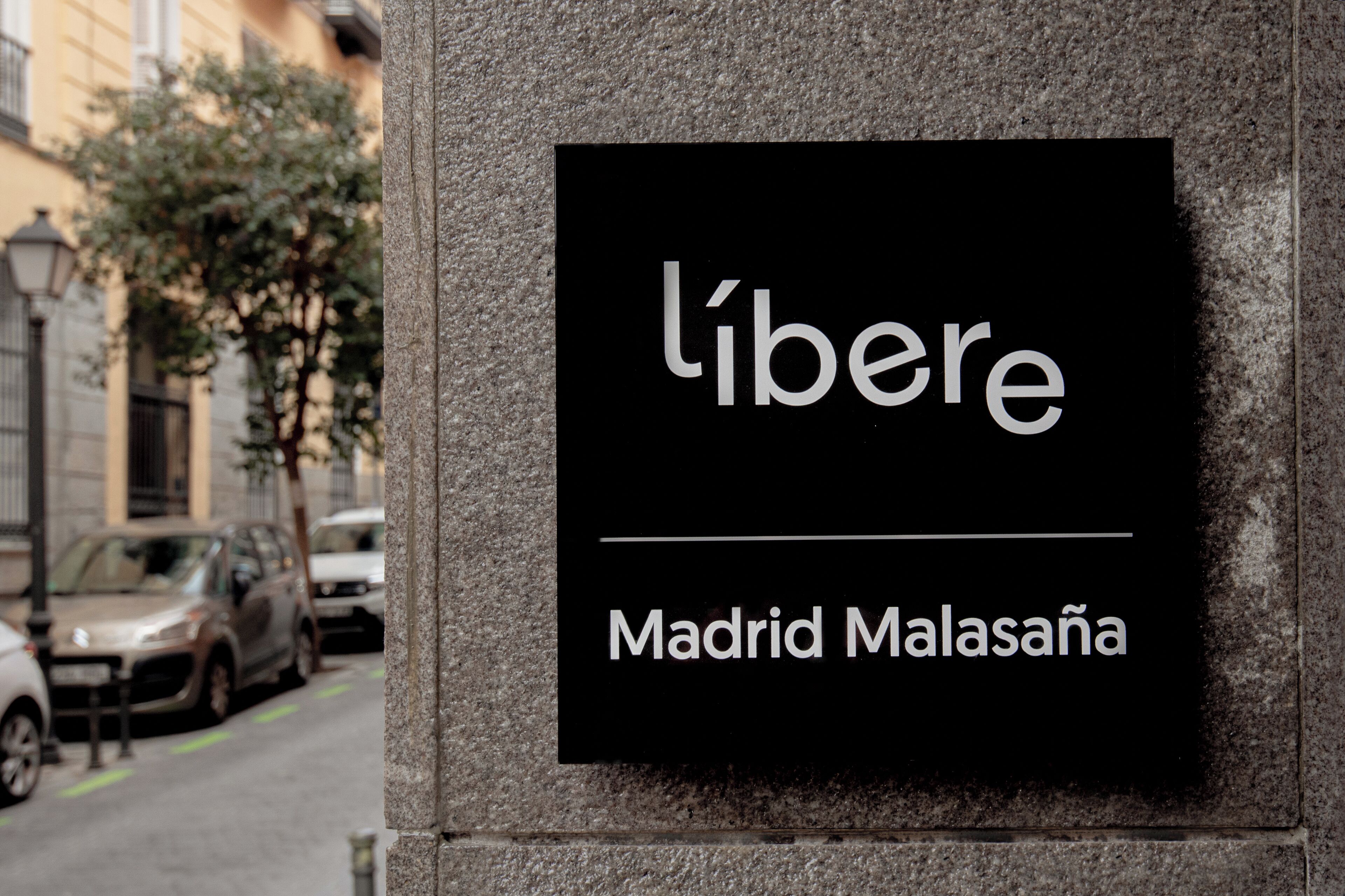 En skylt med namnen ”l’iberé” och ”Madrid Malasaña” på en stenmur.