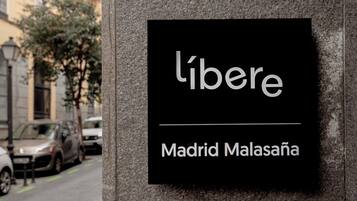 En skylt med namnen ”l’iberé” och ”Madrid Malasaña” på en stenmur.
