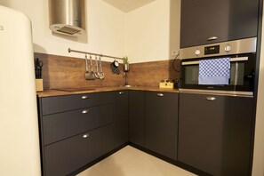 Departamento superior | Cocina privada | Refrigerador con congelador, microondas, horno y parrilla de estufa 