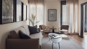 A modern living room with a sofa, chairs, a coffee table, and framed artwork on the walls. - Líbere Madrid Malasaña (Madrid)