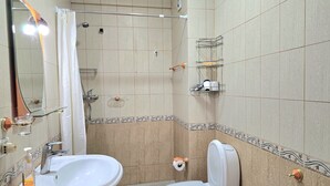 Ein Badezimmer mit Waschbecken, Toilette, Dusche und Spiegel.