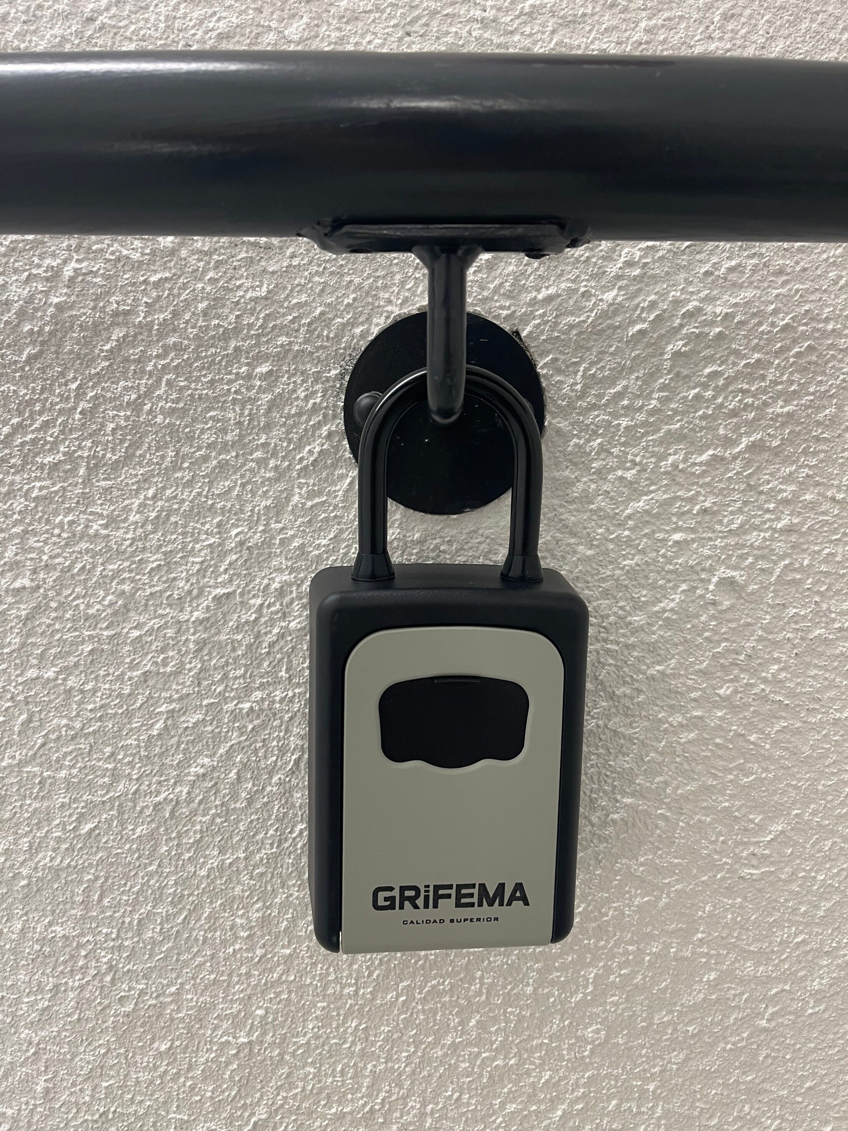 A padlock labeled 'GRIFEMA' attached to a metal bar.
