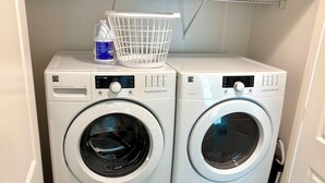 Dues rentadores carregades per la part frontal apilades una sobre l'altra, amb una cistella blanca i una ampolla de detergent a la màquina de dalt.