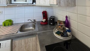 A compact kitchen with a microwave, toaster, coffee maker, and a small sink. - Studio 2OO M Centre Saint Florent -in quiet building. (Saint-Florent)