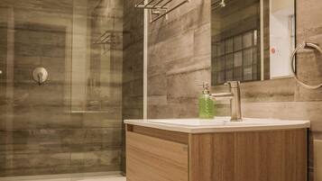 A modern bathroom with a shower, toilet, and vanity.