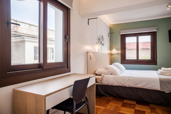 Ein Schlafzimmer mit einem Bett, einem Schreibtisch und einem Stuhl.