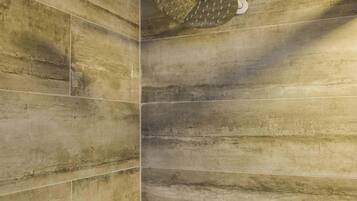 A shower with a unique, textured wall design and a modern showerhead.