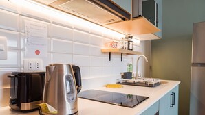 Una cocina moderna con horno integrado, hervidor y cafetera.
