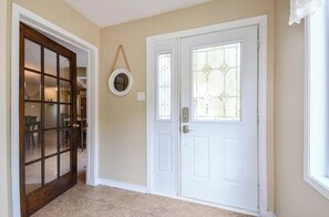 A hallway with a white door and a glass door leading to a dining area. - Chalet Béatitude (Val-des-Bois)