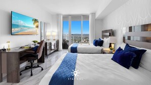 Ein modernes Hotelzimmer mit einem großen Bett, einem Schreibtisch und Blick auf die Stadt.