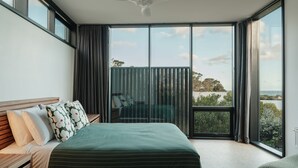 A bedroom with a large bed, a view of the outdoors through a sliding door, and a ceiling fan. - Obliqua - Brand new custom showpiece (Skenes Creek)