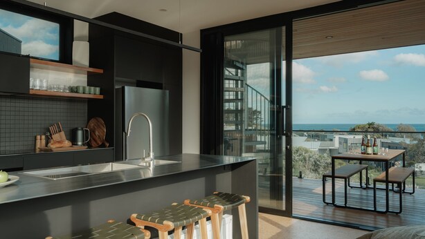 A modern kitchen with a large island, a built-in oven, and a view of the ocean. - Obliqua - Brand new custom showpiece (Skenes Creek)