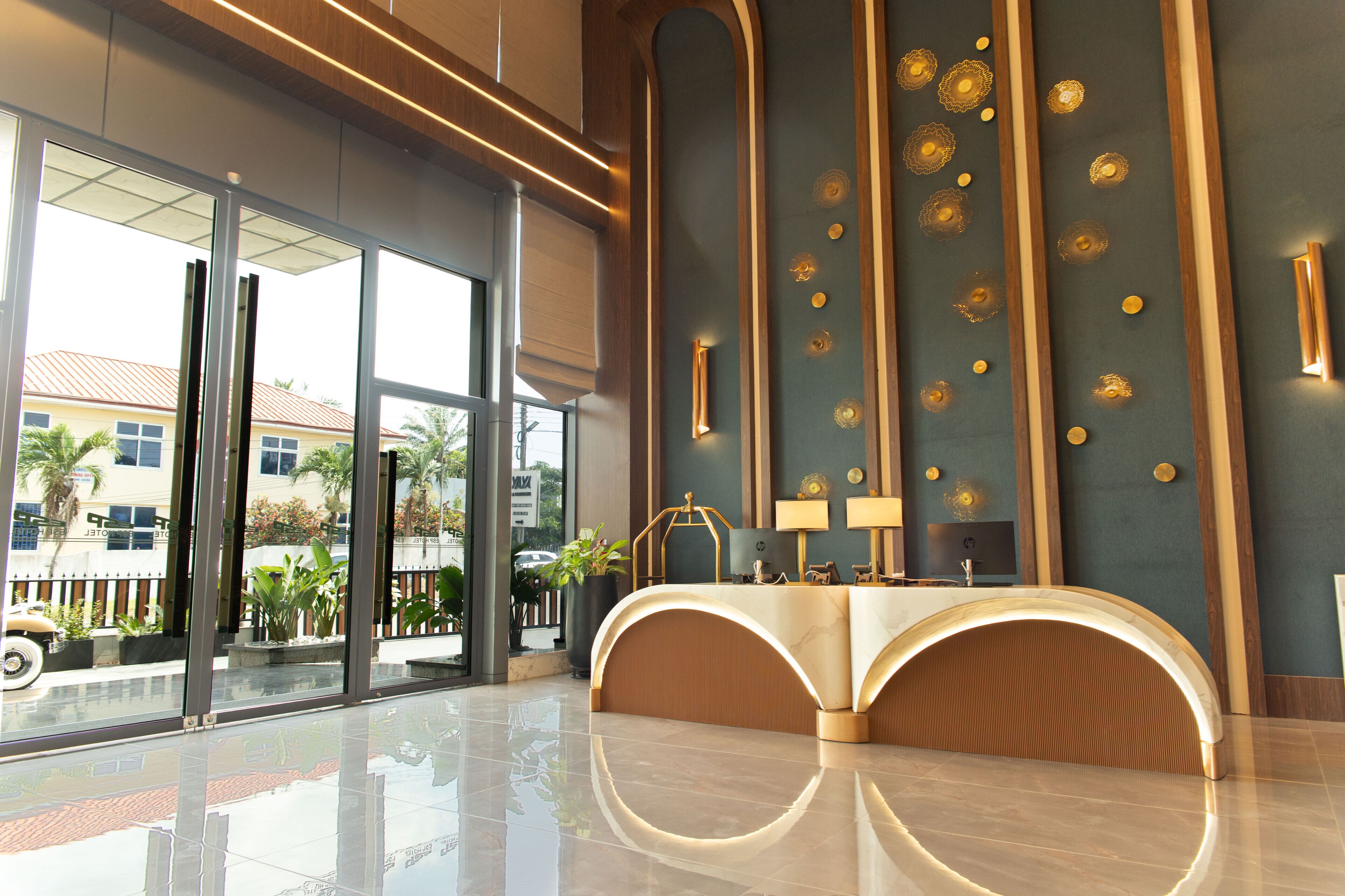 A modern reception area with a curved reception desk, large windows, and a decorative wall with circular patterns.
