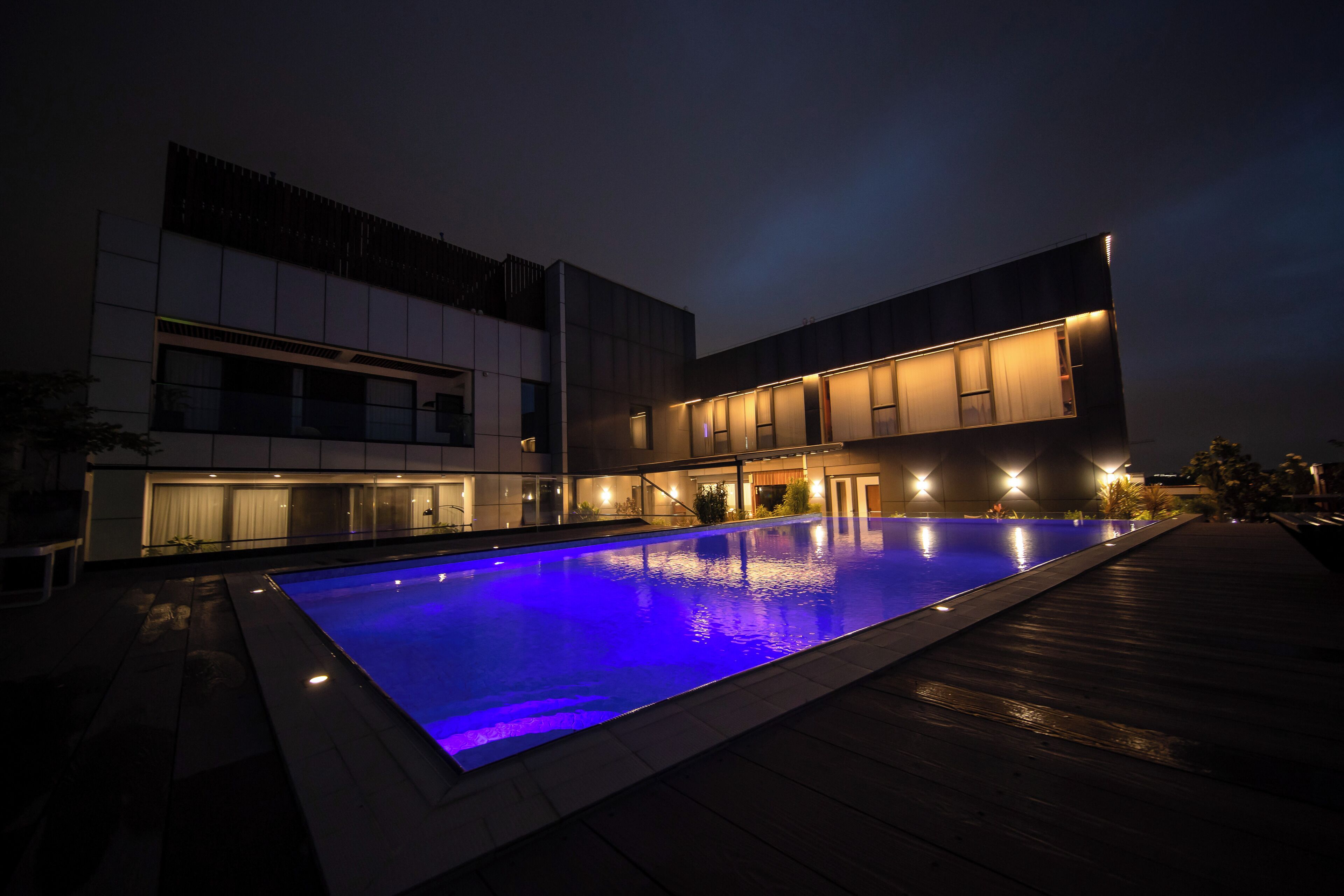 Un bâtiment moderne avec une piscine, de nuit.
