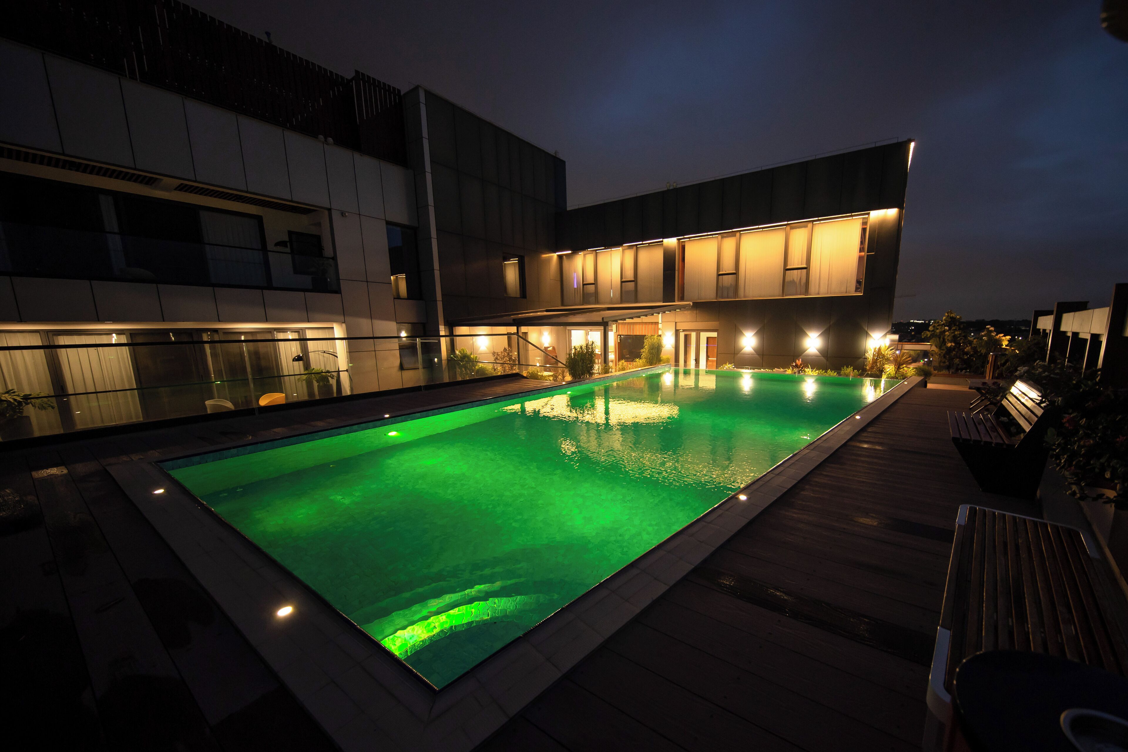 A modern building with a swimming pool at night.