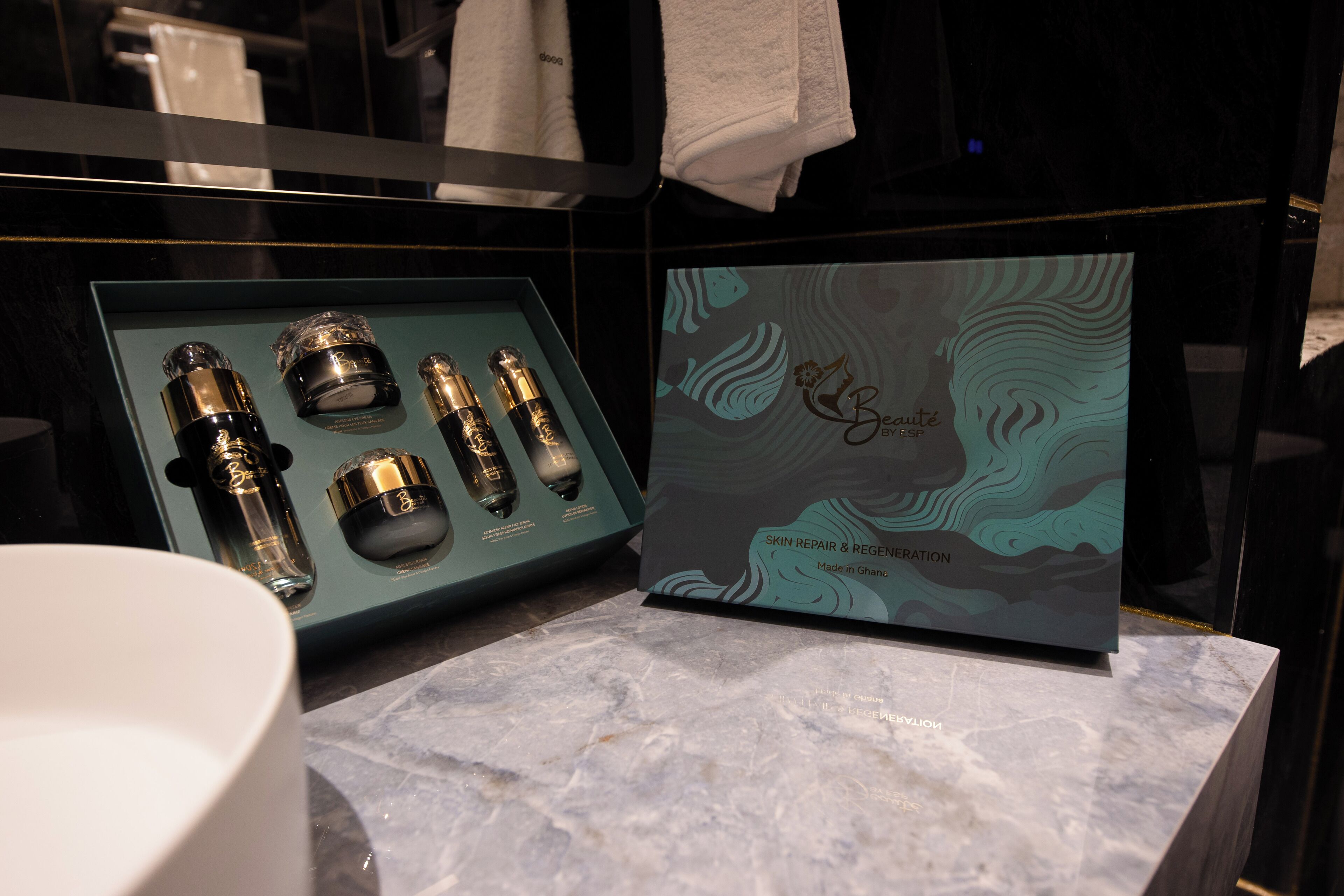 Une présentation de produits de soins pour la peau, avec une boîte et des flacons disposés sur un comptoir en marbre.