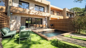 A modern two-story house with a swimming pool, outdoor seating, and a wooden deck. - Villa Benedettu (Lecci)