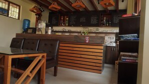 A cozy restaurant with a wooden counter, black menu boards, and a bar area. - Peaceful, Charming- bedroom bed & breakfast in lovely Dhulikhel #1 (Dhulikhel)