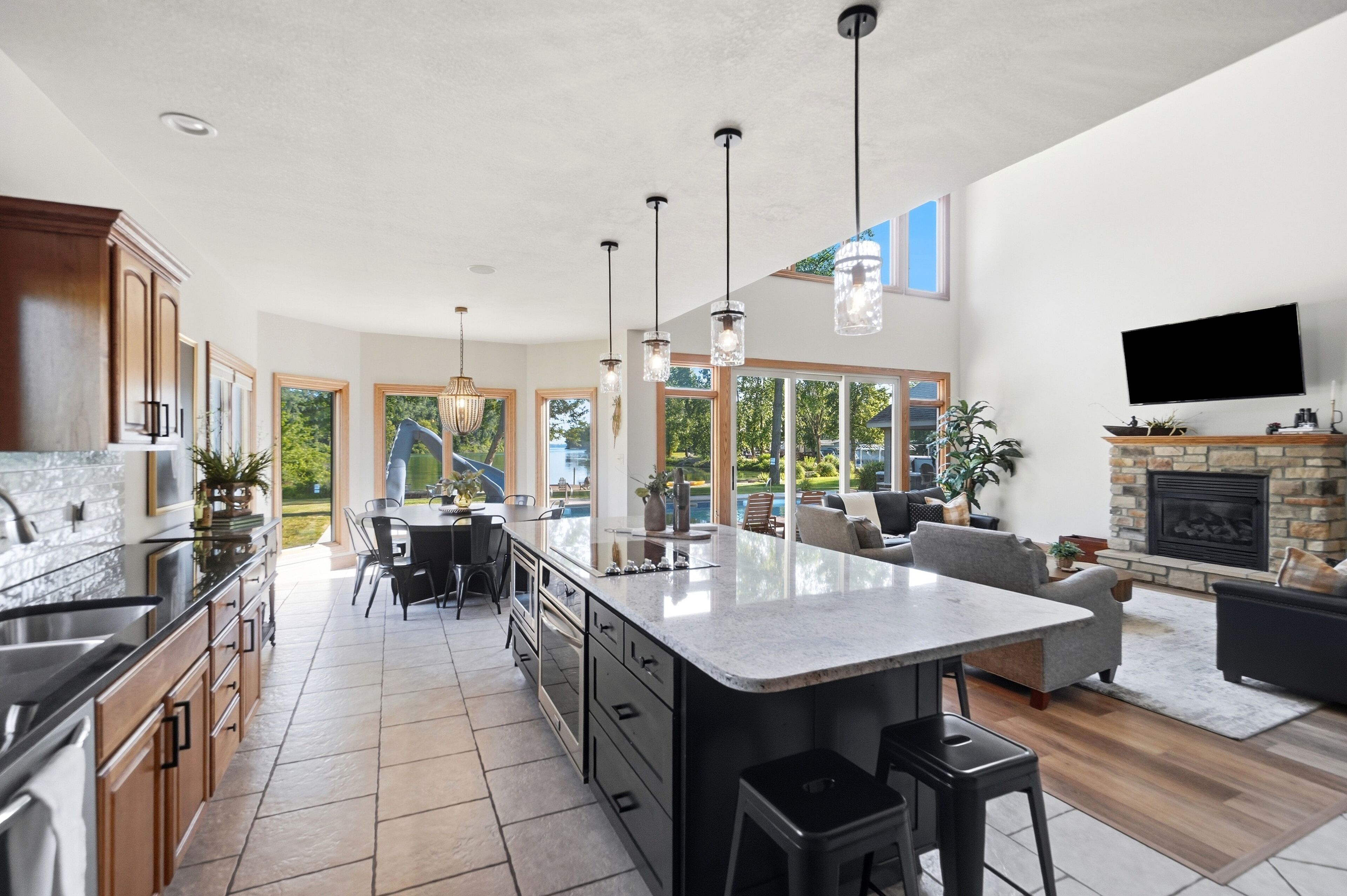 A spacious kitchen with a large island, modern appliances, and a dining area with a view of the outdoors.