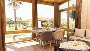 A dining area with a table, chairs, and a view of the outdoors. - Villa Atlas Issen (Eddir)