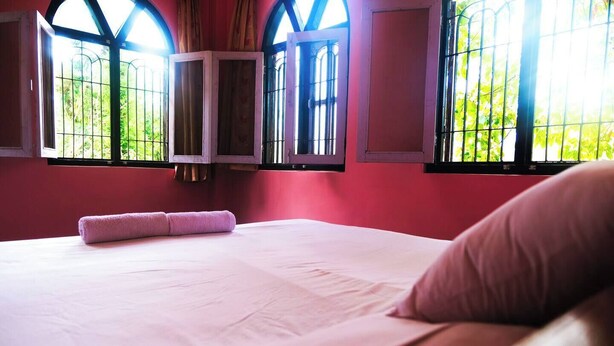 A hotel room with a large bed, a window with metal bars, and a view of greenery outside. - Peaceful, Charming- bedroom bed & breakfast in lovely Dhulikhel #4 (Dhulikhel)