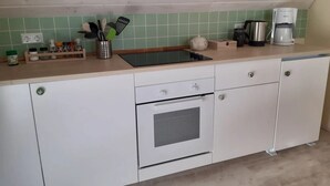 Keittiössä on sisäänrakennettu uuni, kahvinkeitin ja vedenkeitin, jotka ovat sijoitettu työtasolle.