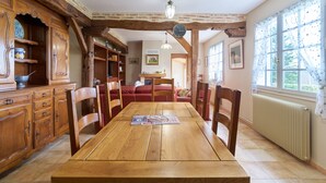 Ein Esszimmer mit Holztisch, Stühlen und einem Schrank mit Schubladen.