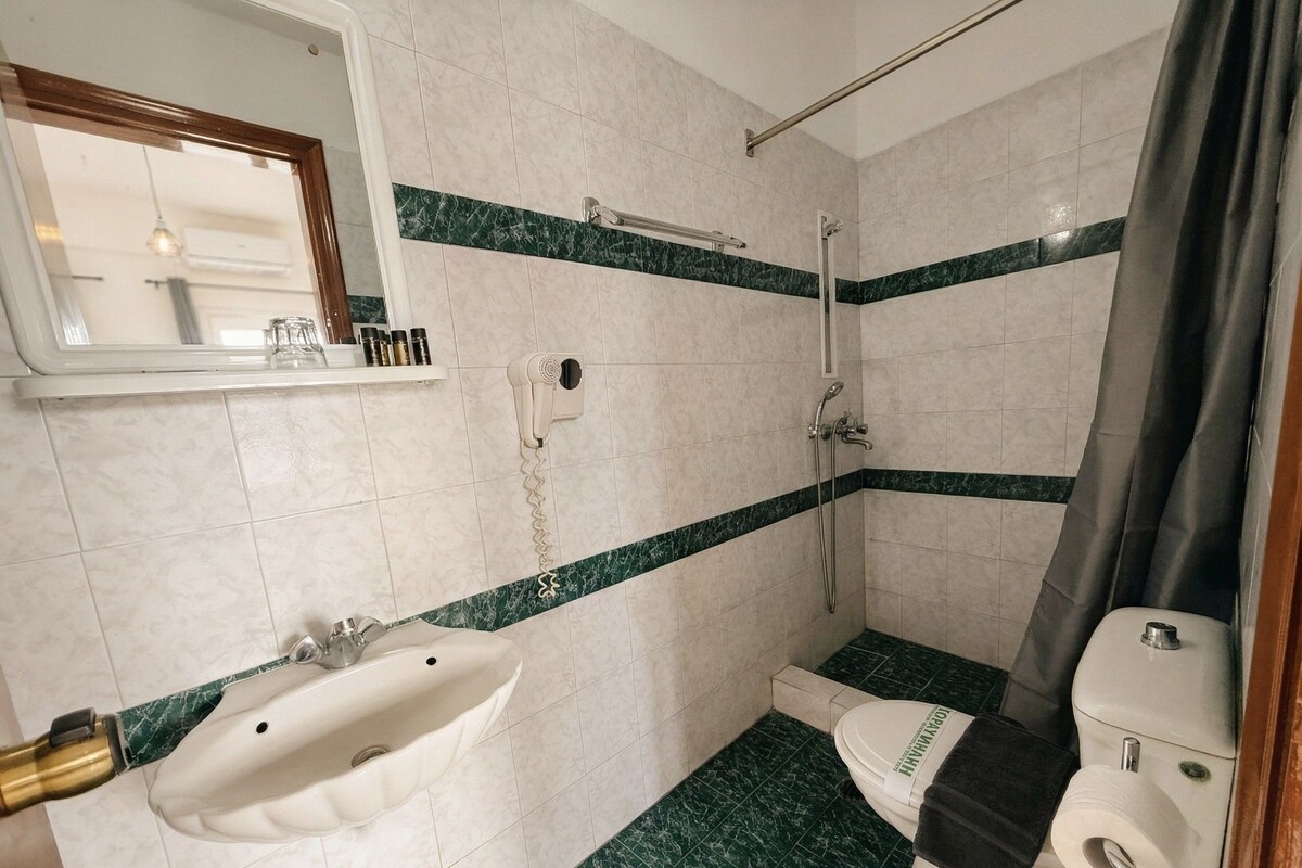 A bathroom with a sink, toilet, and shower.